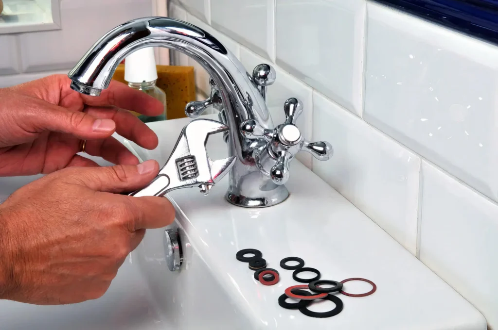 Plumber performing maintenance on a bathroom faucet in Bloomington
