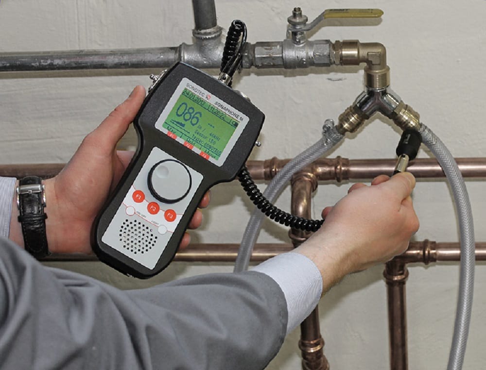 Plumber testing pipes with electronic leak detection equipment in Bloomington