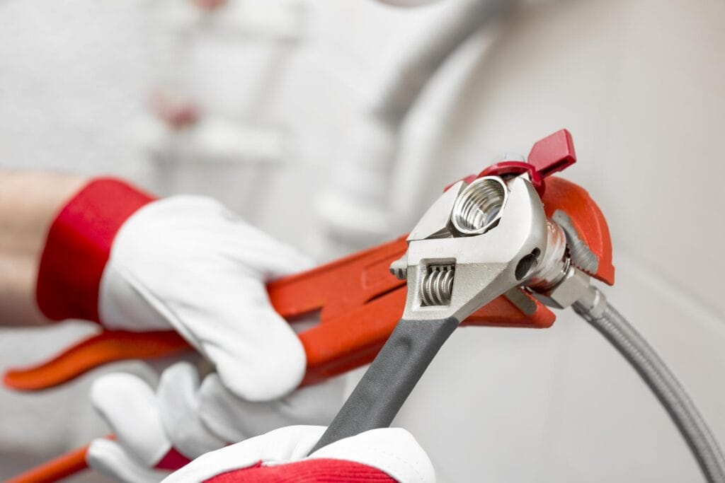 Plumber holding pipe wrenches for an emergency repair in Bloomington