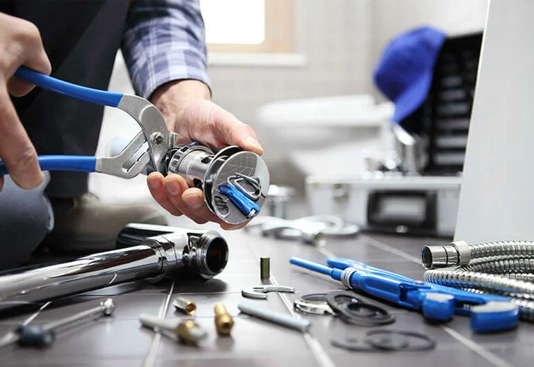 Technician repairing a plumbing fixture with professional tools in Bloomington