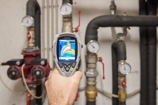Plumber using a thermal imaging camera to inspect pipes in Bloomington