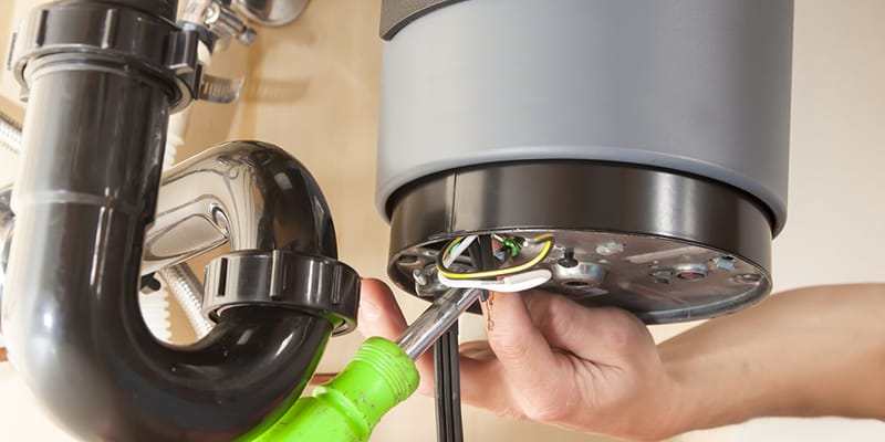 Technician repairing the heating element of a water heater in Bloomington
