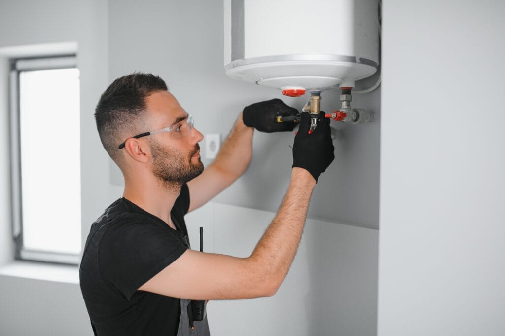 Technician performing water heater maintenance in Bloomington