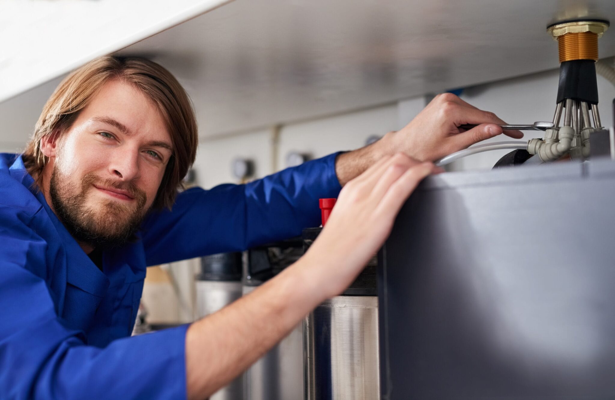 Technician servicing a residential water heater tank in Bloomington