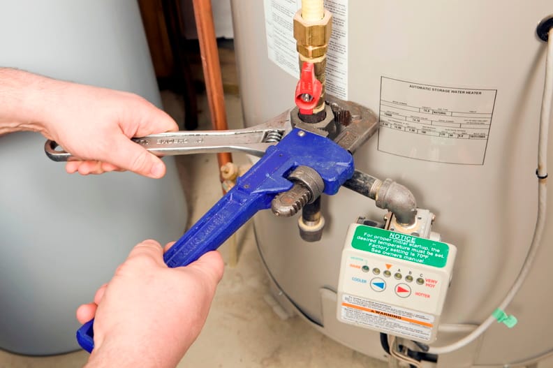 Plumber repairing a water heater valve in Bloomington